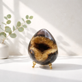 Septarian Dragon Egg / septarian geode med calcitkrystaller indeni.